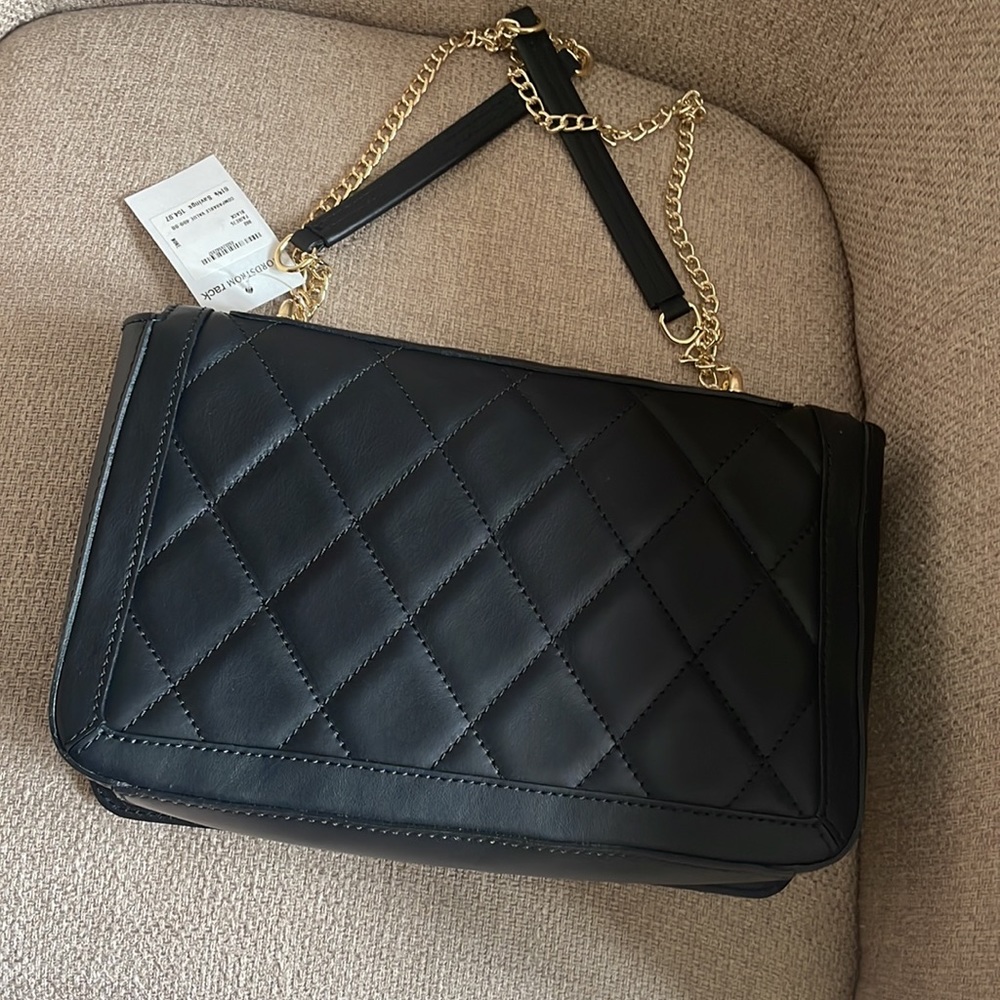 Black quilted bag with convertible chain strap.